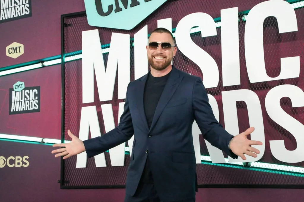 Travis Kelce exudes sophistication in a black suit, a symbol of his expanding career and impressive Travis Kelce Net Worth.