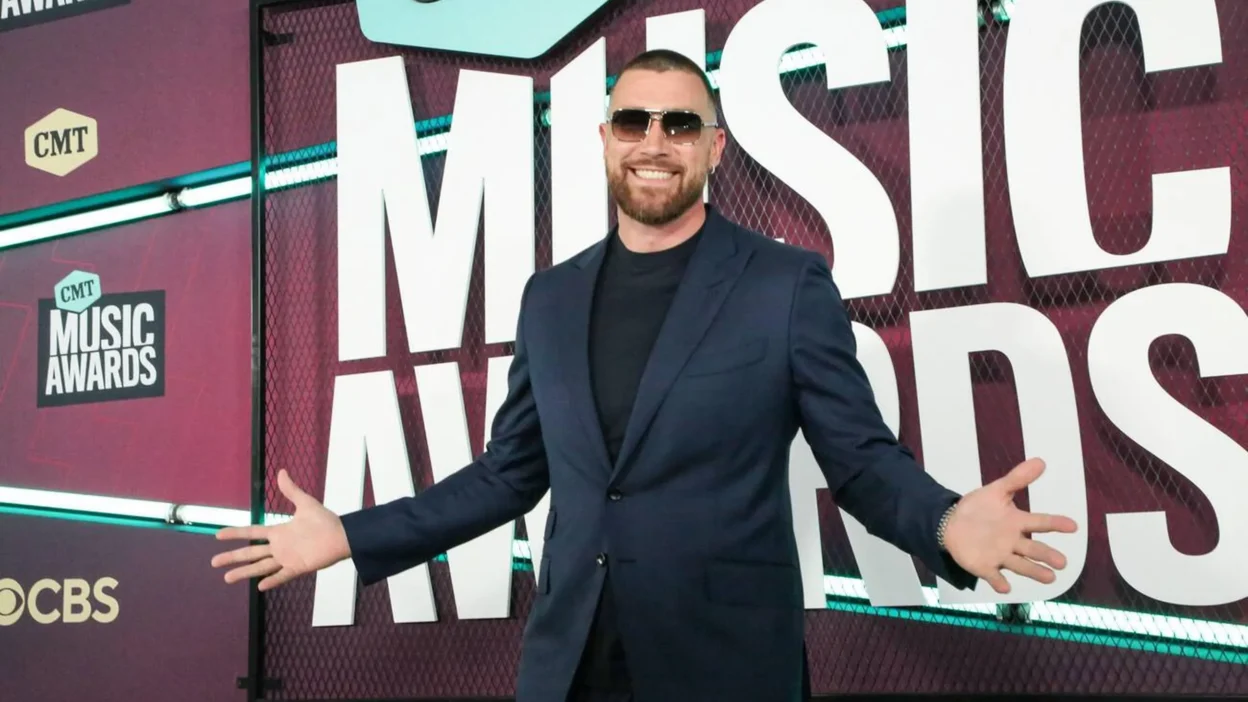 Travis Kelce exudes sophistication in a black suit, a symbol of his expanding career and impressive Travis Kelce Net Worth.