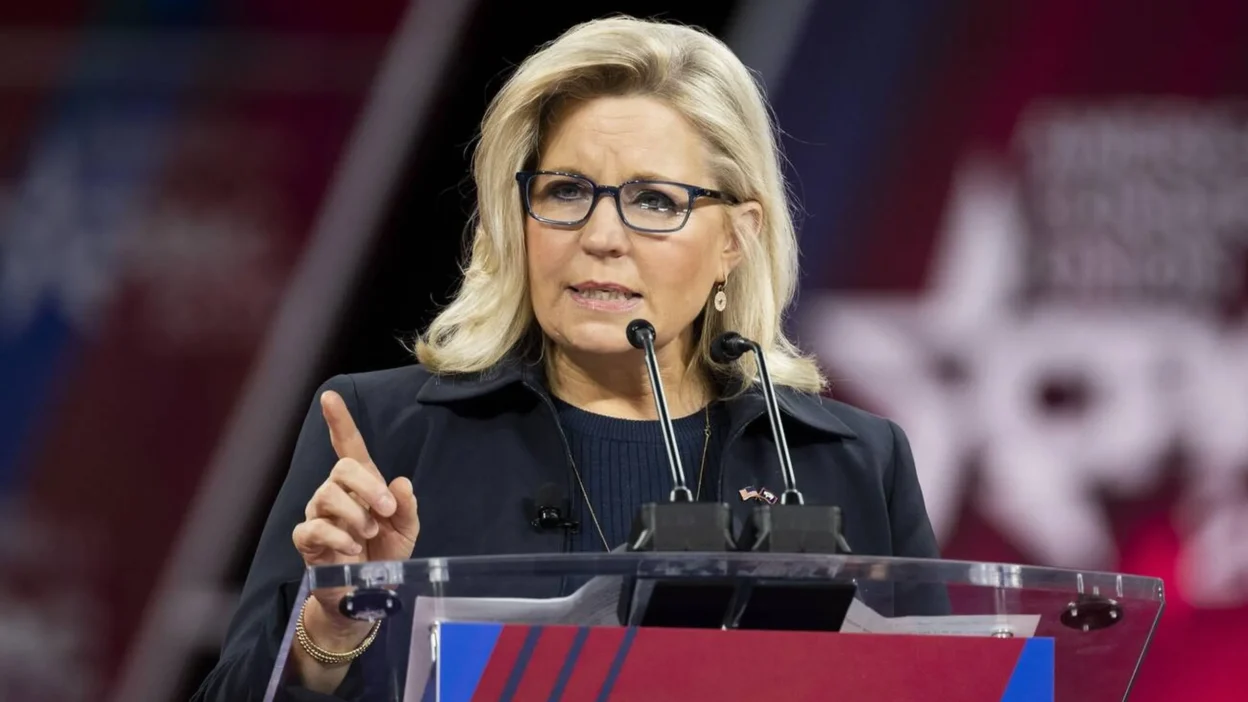 Liz Cheney speaking at a political rally, addressing supporters with determination.