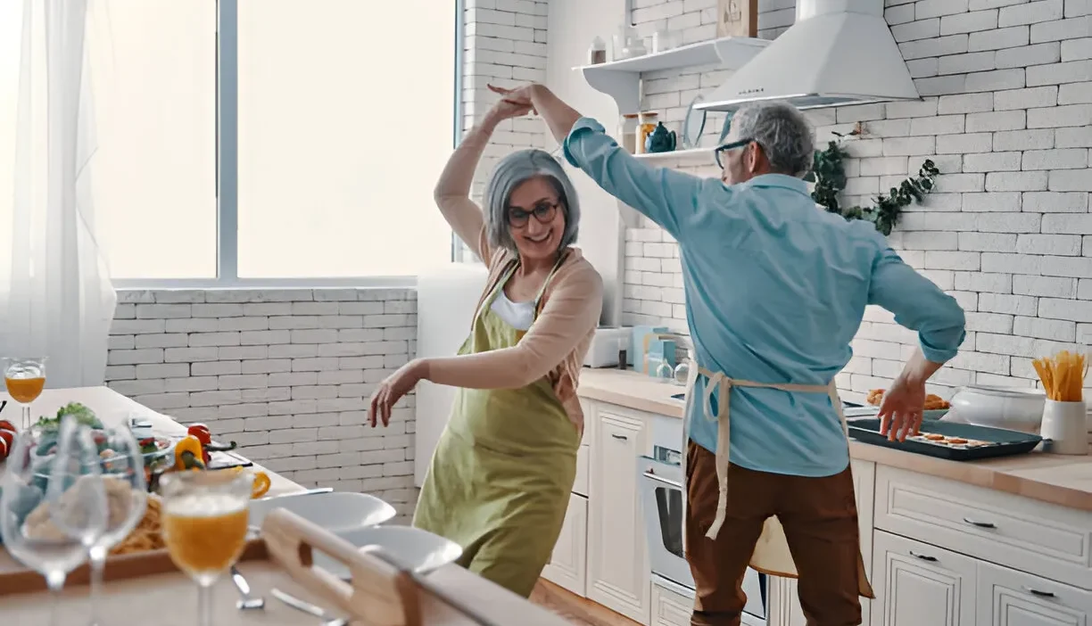 An elderly couple dancing happily, symbolizing the financial freedom and joy that comes with understanding what is the $1000 a month rule for retirement.